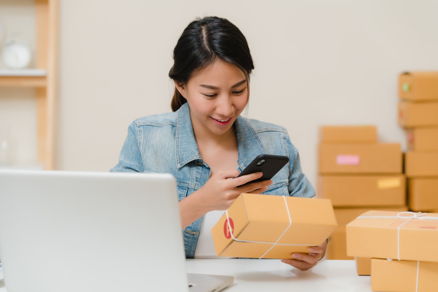 Online seller checking a parcel with her phone