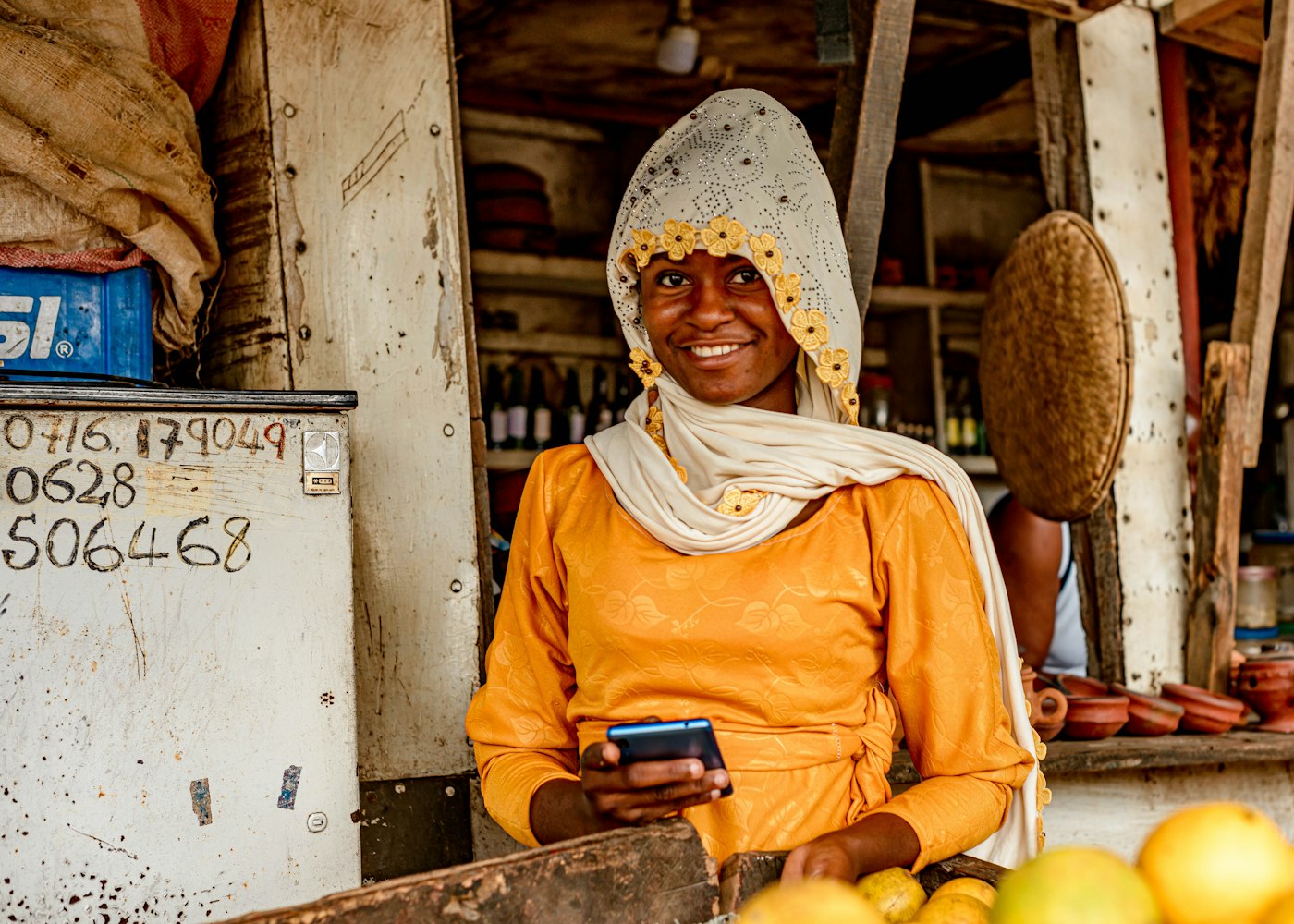 Fruit shop owner checking her phone at the stall
