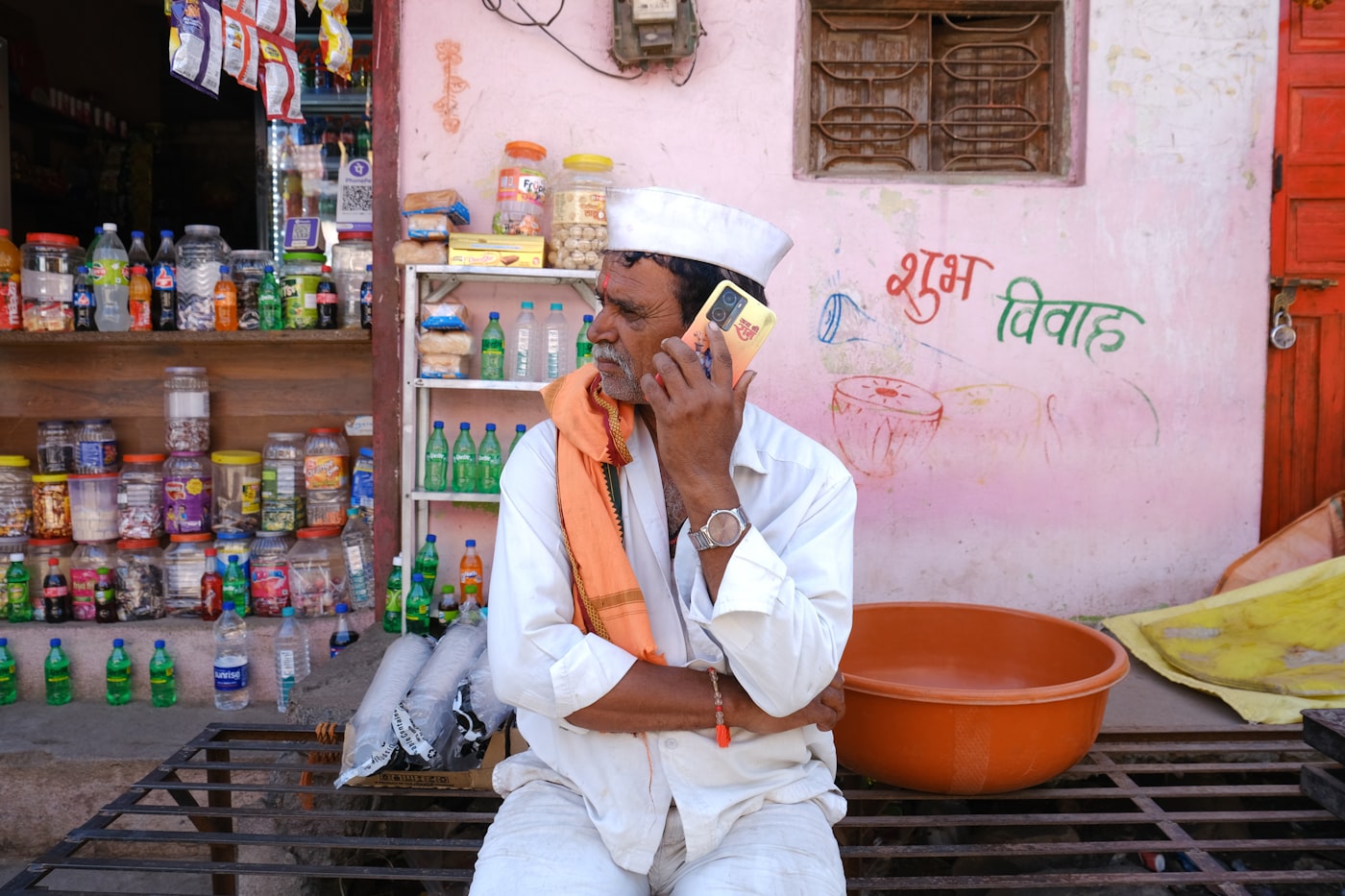 Shopkeeper on the phone in front of his store